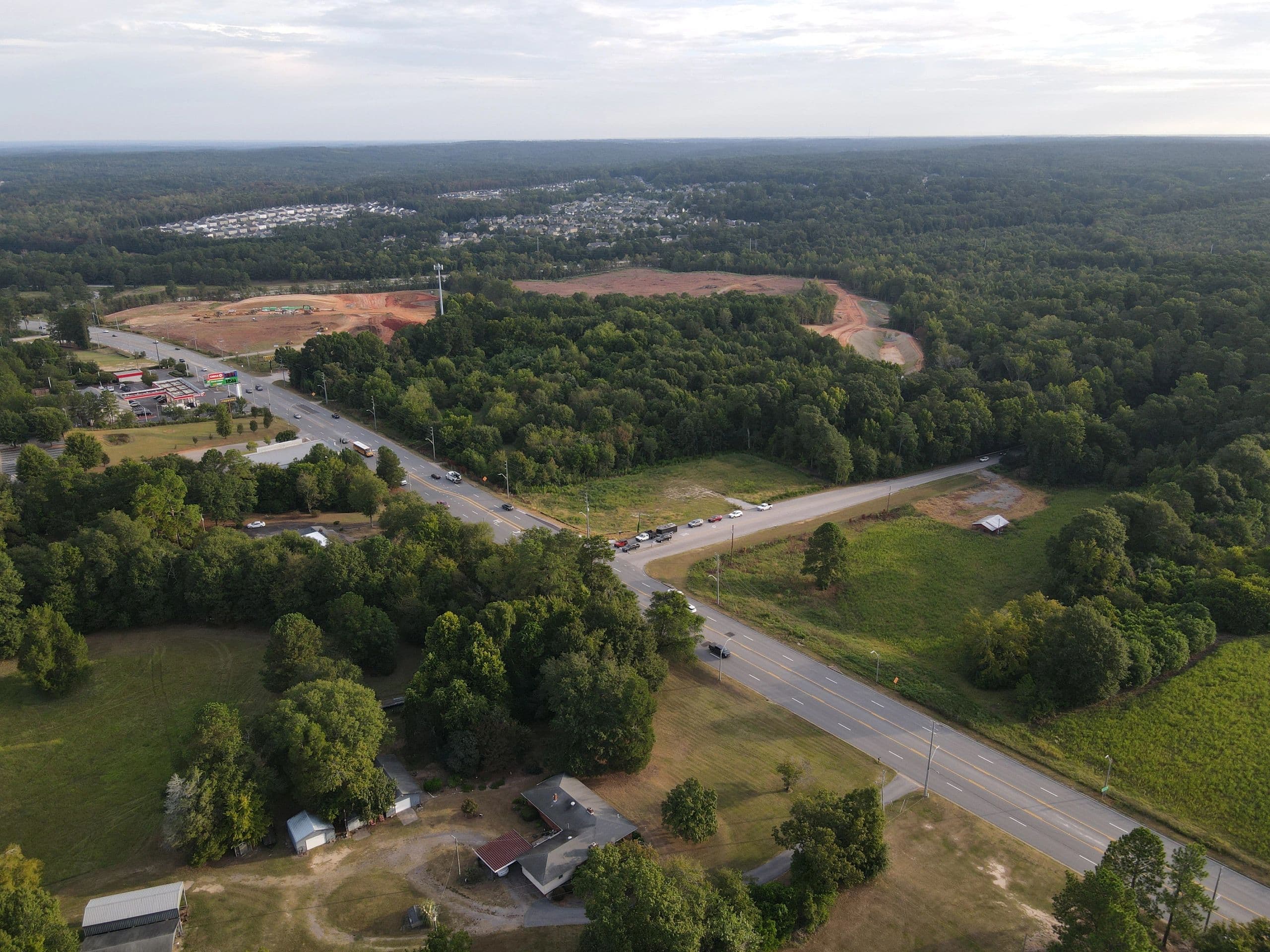 Drone aerial of early site clearing at The Hive with North Augusta neighborhoods beyond