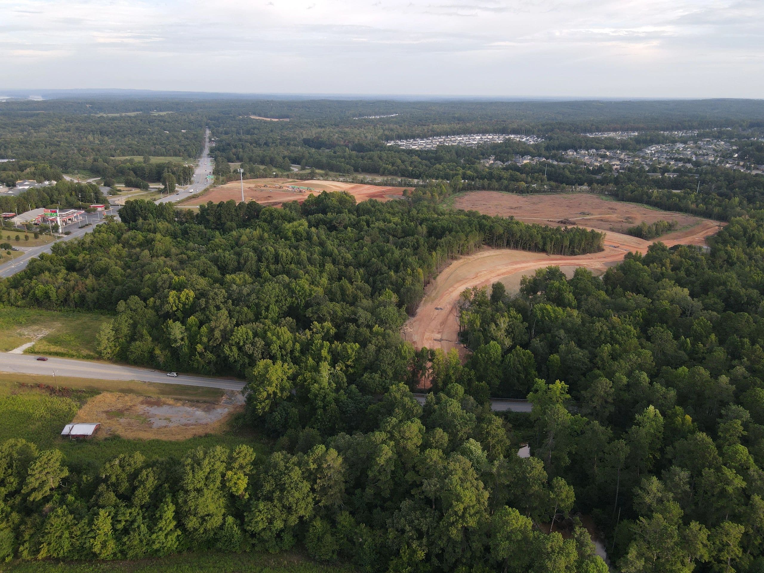 Drone aerial of graded roadways cut through the wooded Hive site